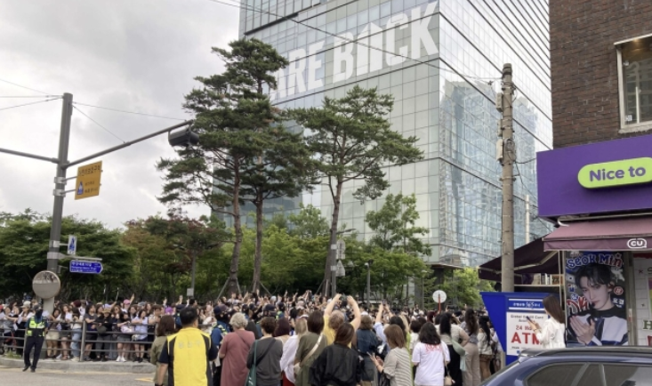 BTS Members RM and V Released, Thousands of Fans Assemble at HYBE Headquarters 3 Celebratory atmosphere with purple outfits and banners